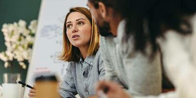 two people in conversation near a flipchart